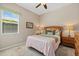 Cozy bedroom with wooden furniture, a queen bed, and a sun-filled window at 12127 Granite Woods Loop, Venice, FL 34292