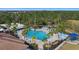 Aerial view featuring a large community pool, surrounded by palm trees, umbrellas, and lounge chairs at 12127 Granite Woods Loop, Venice, FL 34292