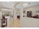 Open foyer with arched entryways leading to a living room and office with tile flooring at 12127 Granite Woods Loop, Venice, FL 34292