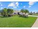 Well-manicured front yard with vibrant landscaping, palm trees, and a charming single-story home at 12127 Granite Woods Loop, Venice, FL 34292