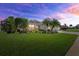 Beautiful home at sunset with a lush lawn, elegant landscaping, and inviting curb appeal at 12127 Granite Woods Loop, Venice, FL 34292