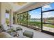 Relaxing screened-in lanai with water view, outdoor furniture, and lush landscaping at 12127 Granite Woods Loop, Venice, FL 34292