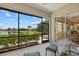 Screened lanai with beautiful lake views, comfortable seating, and an open doorway to a stone path at 12127 Granite Woods Loop, Venice, FL 34292
