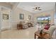 Comfortable living room with tile floors, ceiling fan, and sliding glass doors to the lanai at 12127 Granite Woods Loop, Venice, FL 34292