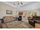 Spacious living room featuring decorative rug, fireplace, and ceiling fan at 12127 Granite Woods Loop, Venice, FL 34292