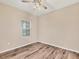 Simple, empty bedroom featuring a window for natural light, and wood flooring at 12198 Sebring Ln, Venice, FL 34293