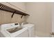 Clean laundry area featuring modern washer and dryer with floating shelf at 12198 Sebring Ln, Venice, FL 34293