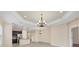 Bright living room open to the kitchen and dining area, featuring tray ceilings at 12198 Sebring Ln, Venice, FL 34293