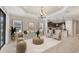 Bright living room with stylish furniture, open to kitchen, tray ceilings, and access to outdoor patio at 12198 Sebring Ln, Venice, FL 34293