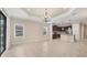 Bright living room open to kitchen, featuring tray ceilings and large windows at 12198 Sebring Ln, Venice, FL 34293
