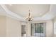 Open living space featuring decorative ceiling, chandelier lighting, and sliding glass doors to an outdoor area at 12198 Sebring Ln, Venice, FL 34293