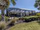 A beautiful view of the home's screened in lanai, pool, and landscaping at 125 Savona, North Venice, FL 34275