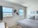 Bright bedroom with large windows offering ocean views and featuring cozy decor and furnishings at 1255 Tarpon Center Dr # 503, Venice, FL 34285