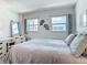 Bright bedroom featuring two windows, a dressing table and a cozy queen-sized bed at 1255 Tarpon Center Dr # 503, Venice, FL 34285