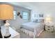 Cozy bedroom features neutral tones, plush bedding, and natural light from the ocean view windows at 1255 Tarpon Center Dr # 503, Venice, FL 34285