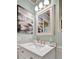 Clean and updated bathroom vanity with stylish mirror and coastal artwork at 13534 Alberta Ave, Port Charlotte, FL 33981