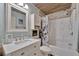 Charming bathroom with stone tiled accents and a shower/tub with octopus themed shower curtain at 13534 Alberta Ave, Port Charlotte, FL 33981