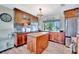 Inviting kitchen featuring wooden cabinets, a butcher block island, and a large window with a tropical view at 13534 Alberta Ave, Port Charlotte, FL 33981