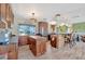 Open kitchen features wood cabinets, stainless appliances, granite counters, and modern lighting at 13534 Alberta Ave, Port Charlotte, FL 33981
