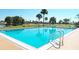 Relaxing community pool with clear blue water, palm trees, and easy access ladder at 13534 Alberta Ave, Port Charlotte, FL 33981