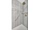 Modern shower featuring sleek gray tile, convenient grab bar, and a mounted shower head with ample space at 13534 Alberta Ave, Port Charlotte, FL 33981
