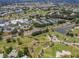 Aerial shot showcasing the community's golf course, lakes, pools, and tennis courts amidst lush greenery at 142 Braemar Ave, Venice, FL 34293