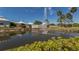 Scenic pond with a fountain surrounded by lush landscaping and community buildings at 142 Braemar Ave, Venice, FL 34293