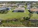 Aerial view of home showing the expansive green lawn, landscaping, and beautiful lake views at 1602 Jim Jim Ct, Venice, FL 34293