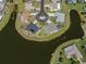 An aerial view shows a waterfront home and cul-de-sac surrounded by a tranquil pond in a residential neighborhood at 1602 Jim Jim Ct, Venice, FL 34293