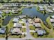 Bird's eye view of a waterfront property in a residential community with mature landscaping and waterfront views at 1602 Jim Jim Ct, Venice, FL 34293