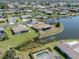 An aerial perspective of the property with a waterfront view in a quiet neighborhood with lush landscaping at 1602 Jim Jim Ct, Venice, FL 34293
