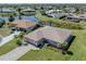 Aerial view of a charming single-Gathering home, surrounded by lush greenery and a tranquil waterfront at 1602 Jim Jim Ct, Venice, FL 34293