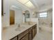 Bright bathroom with double sinks, wooden cabinets, and a shower-tub combo at 1602 Jim Jim Ct, Venice, FL 34293