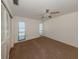Bright bedroom featuring neutral carpet, a ceiling fan, and two windows for natural light at 1602 Jim Jim Ct, Venice, FL 34293