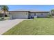 The exterior of this inviting home features a well-manicured lawn, a paved driveway, and an attached garage at 1602 Jim Jim Ct, Venice, FL 34293