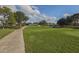 Lush golf course with a scenic path leading towards the clubhouse and pond at 1602 Jim Jim Ct, Venice, FL 34293