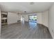 Bright living room with gray laminate floors and sliding doors leading to the screened lanai at 1602 Jim Jim Ct, Venice, FL 34293