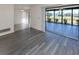 Open living room featuring gray wood-look floors and sliding door access to the lanai at 1602 Jim Jim Ct, Venice, FL 34293