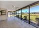 Serene sunroom with tile flooring, ceiling fans, and scenic views of the backyard pond at 1602 Jim Jim Ct, Venice, FL 34293