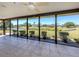 Relaxing sunroom with neutral tile, fan and expansive windows overlooking the backyard and pond at 1602 Jim Jim Ct, Venice, FL 34293