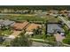 An aerial view of homes featuring beautiful tile roofs with a pond and nature preserve in the background at 1662 Bobcat Trl, North Port, FL 34288