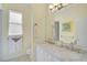 Well lit bathroom with double sinks, and a bright window with a decorative painting at 1662 Bobcat Trl, North Port, FL 34288