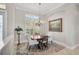 Dining room features a window with shutters, a chandelier, and neutral decor at 1662 Bobcat Trl, North Port, FL 34288