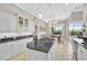 Open kitchen features white cabinets, granite countertops, a cooktop island, and dining area views at 1662 Bobcat Trl, North Port, FL 34288