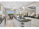 Kitchen with granite counters, pendant lights, island cooktop, and a view of the dining area and pool at 1662 Bobcat Trl, North Port, FL 34288