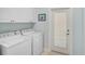 A clean and organized laundry room with washer, dryer, cabinets, and an exterior door at 1662 Bobcat Trl, North Port, FL 34288
