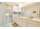 Elegant bathroom featuring a double sink vanity, large mirror, and a glass-enclosed shower at 1683 San Silvestro Dr, Venice, FL 34285