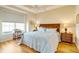 Cozy bedroom with ample natural light, wood floors, ceiling fan, and comfortable queen-sized bed at 1683 San Silvestro Dr, Venice, FL 34285