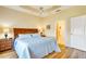 Comfortable bedroom featuring a ceiling fan, wood floors, and view to the ensuite bathroom at 1683 San Silvestro Dr, Venice, FL 34285