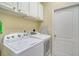 Functional laundry area equipped with a washer, dryer, storage cabinets, and ironing board at 1683 San Silvestro Dr, Venice, FL 34285
